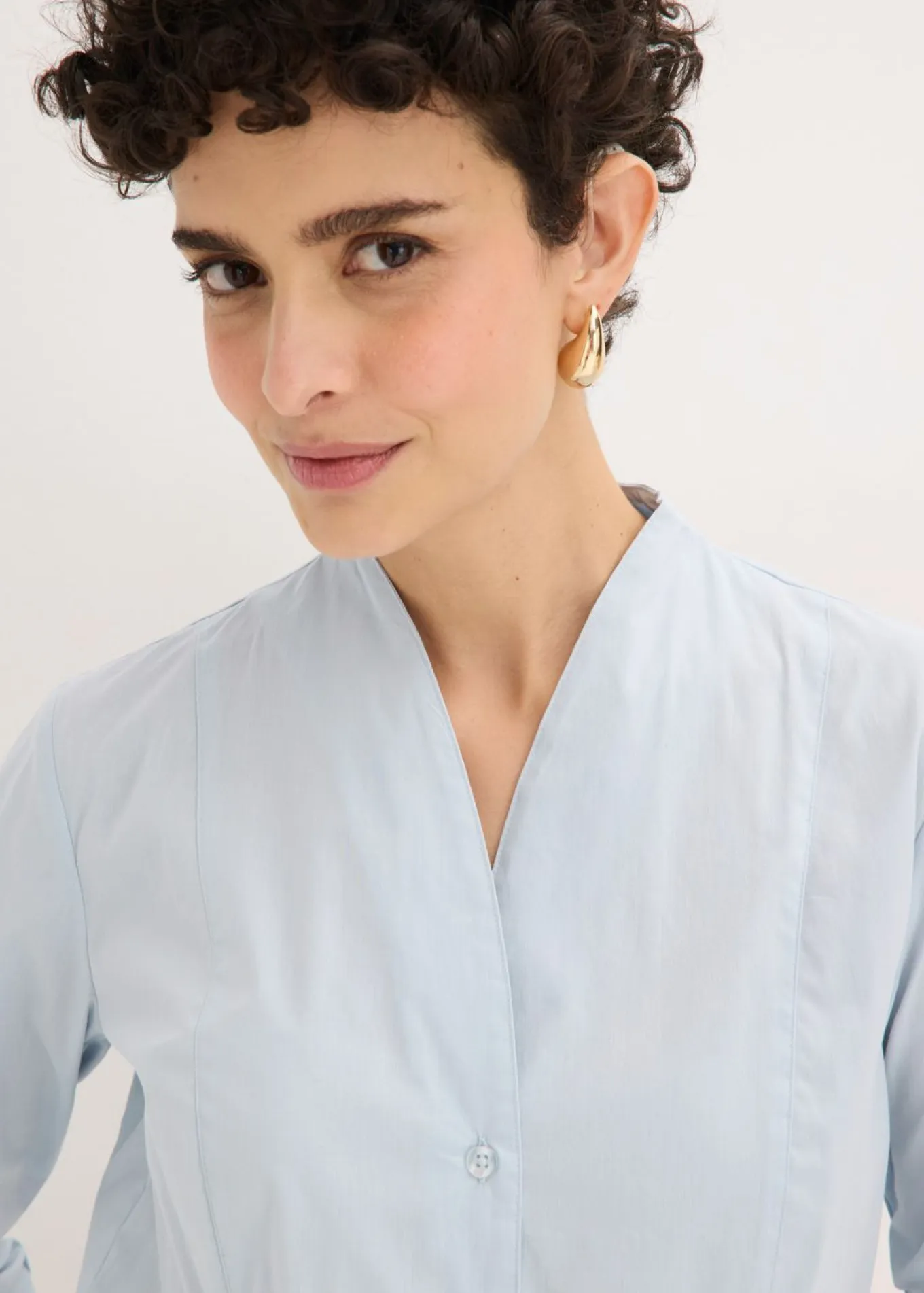 Blusa elástica de popelín con cuello chimenea y ligera transparencia