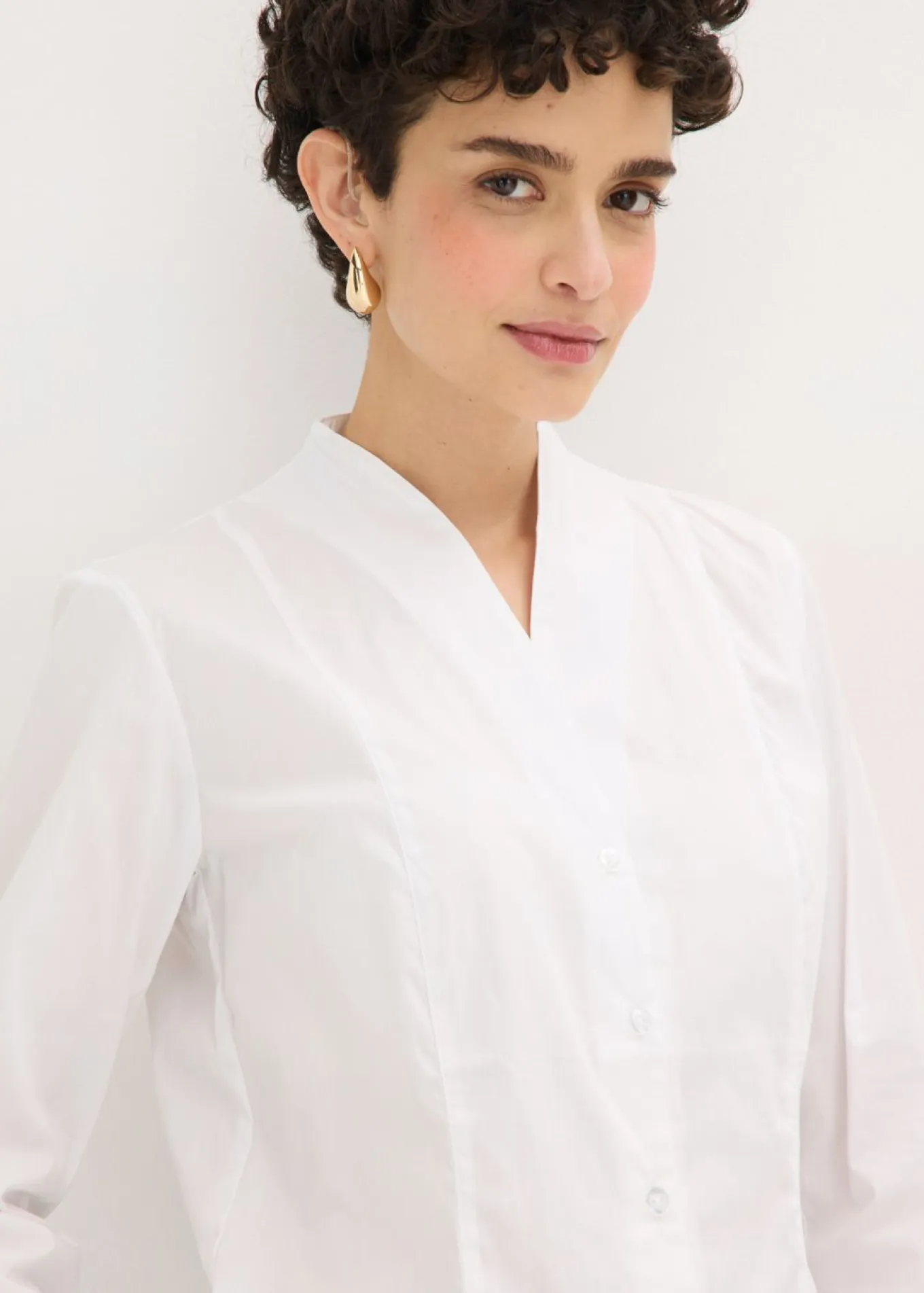 Blusa elástica de popelín con cuello chimenea y ligera transparencia